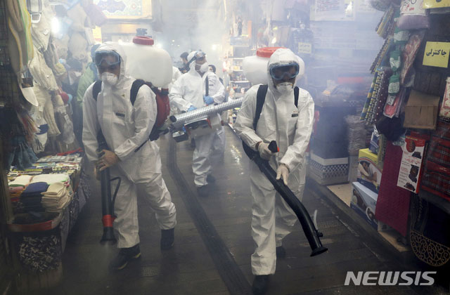▲ 테헤란의 한 시장에서 방역작업을 하는 이란 보건당국 관계자들. ⓒ뉴시스 AP. 무단전재 및 재배포 금지.