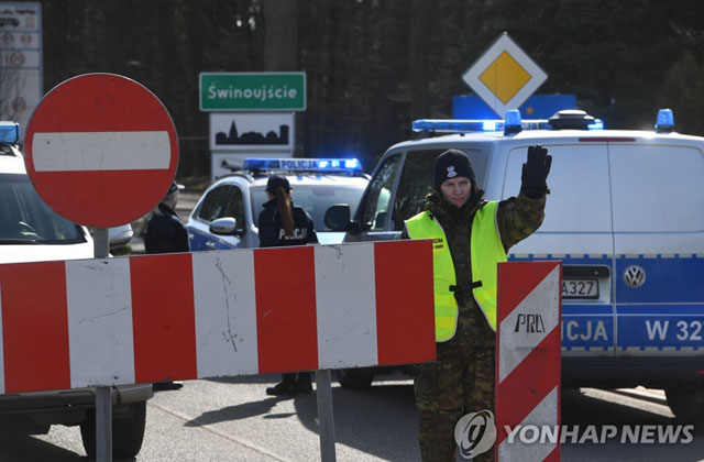 ▲ 독일 쪽에서 다가오는 차량을 향해 멈추라고 신호하는 폴란드 국경수비대. ⓒ연합 DPA. 무단전재 및 재배포 금지.