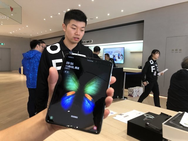 ▲ 중국 상하이 번화가 난징둥루에 있는 삼성전자 플래그십 매장에서 한 고객이 갓 구매한 갤럭시 폴드 제품을 손에 들어 살펴보고 있다. ⓒ연합뉴스