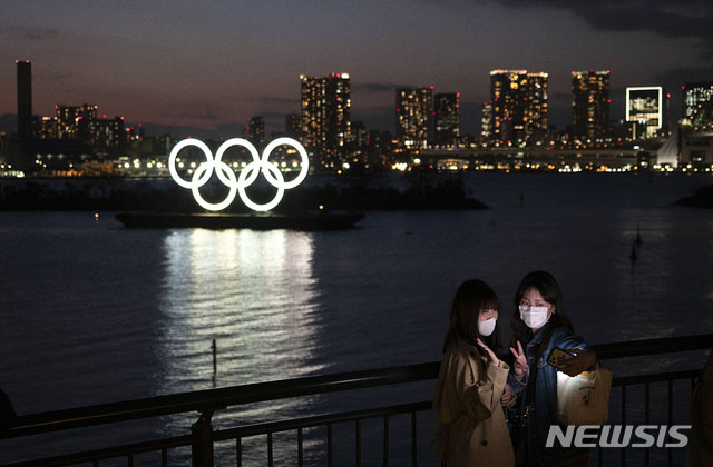 ▲ 도쿄올림픽 상징물을 배경으로 사진을 찍는 여성들. ⓒ뉴시스 AP. 무단전재 및 재배포 금지.
