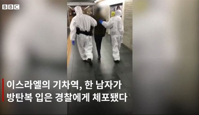 ▲ 이스라엘의 한 기차역에서 방호복을 입은 사람 2명이 한 남성을 체포해 끌고 간다. 방호복을 입은 사람들은 국내정보기관 신베트 요원이고, 붙잡힌 사람은 우한코로나 확진판정을 받은 뒤 병원에서 도망친 사람이라고 한다. ⓒ영국 BBC 한국어판 영상캡쳐.