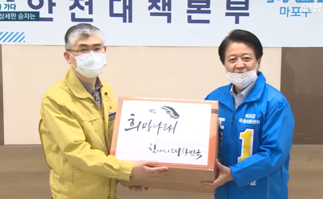 ▲ 더불어민주당 노웅래 마포구갑 후보가 마포구 측에 마스크 400장을 전달하고 있다. ⓒ유튜브 채널 '연합뉴스TV' 영상 갈무리