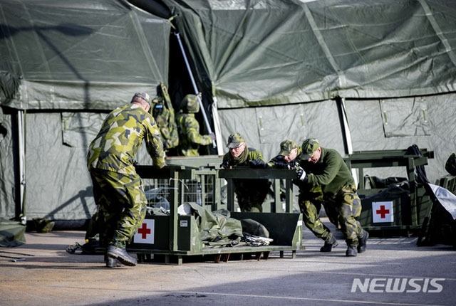 ▲ 지난 3월 23일(현지시간) 우한코로나 중환자를 위한 야전병원을 짓고 있는 스웨덴 군 장병. ⓒ뉴시스 AP. 무단전재 및 재배포 금지.