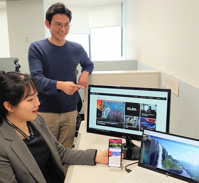▲ LG디스플레이 직원들이 개편된 올레드 스페이스 화면을 보고 있다. ⓒLG디스플레이