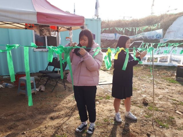 ▲ 사랑의 일기연수원 관련 학생들이 일기연수원 컨테이너 사무실 앞에서 리본을 달고 있다.ⓒ인추협