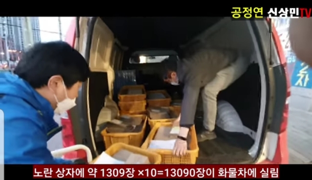 ▲ 공정연신상민TV에서 지난 11일 사전투표 종료 후 선관위에서 우체국으로 이송되는 모습을 찍은 영상. 관외 투표봉투가 노란 상자에 담겨 우체국 차량에 실리고 있다. ⓒ유튜브 캡쳐