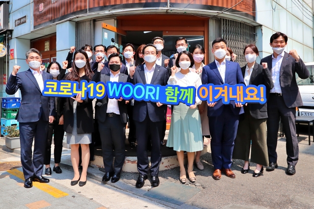 ▲ 우리금융은 코로나19로 어려움을 겪고 있는 본점 인근 음식점을 돕기 위해 착한소비운동에 동참한다. 손태승(가운데) 우리금융 회장이 16일 본점 인근 식당에서 임직원들과 점심식사 후 코로나19로 어려움을 겪고있는 이들에게 응원의 메시지를 보내고 있다. ⓒ우리금융