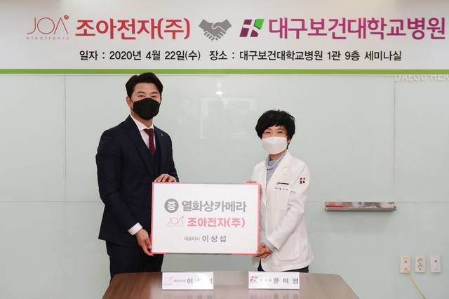 ▲ 이상섭 조아전자 대표(왼쪽)가 대구보건대병원에서 열화상 카메라 기증식을 개최한 가운데 황미영 병원장(오른쪽)과 기념촬영을 하고 있다.ⓒ대구보건대병원