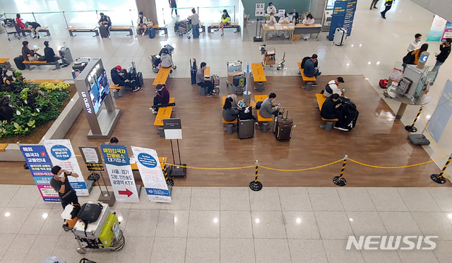 ▲ 인천공항에 입국한 승객들이 각 지역으로 가는 수송차량에 탑승하기 전 대리를 하고 있다. ⓒ뉴시스