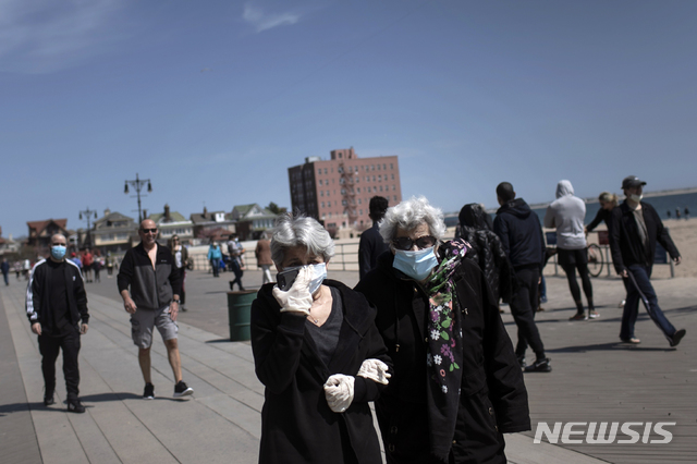 ▲ 미국 뉴욕 브라이턴 해변에서 시민들이 마스크와 장갑을 착용한채 산책을 하고 있다. ⓒ뉴시스