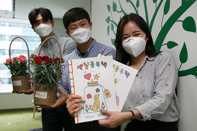 ▲ 현대글로비스는 5월 가정의 달을 맞아 홀몸 어르신께 후원물품(컬러링 북·꽃 화분·식료품)을 전달하는 나눔 봉사활동을 진행했다. 사진은 현대글로비스 직원들이 홀몸 어르신께 전달한 후원물품을 소개하는 모습. ⓒ현대글로비스