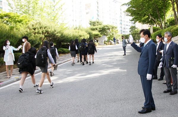 ▲ 김병우 충북도교육감이 20일 금천고에서 등교하는 고3 학생들에게 손을 흔들며 인하고 있다.ⓒ충북도교육청