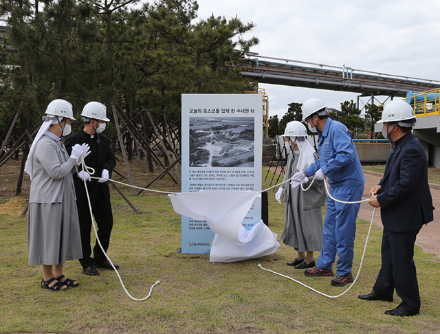 ▲ 20일 포항제철소 내 3고로공장에서 진행된 제막식에서 김알로이시아 예수성심시녀회원장(왼쪽 1번째), 최재영 천주교 4대리교구장 신부(왼쪽 2번째), 남수희 포항제철소장(왼쪽 4번째) 등 관계자들이 입간판을 공개하고 있다.ⓒ포스코