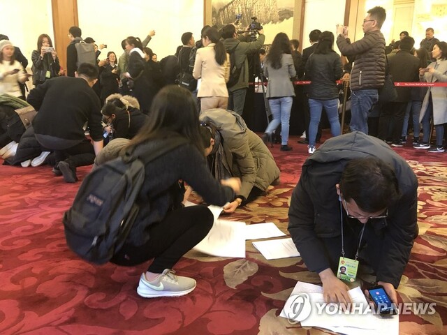 ▲ 중국 전국인민대표대회가 개막한 5일 오전 인민대회당에서 기자들이 정부업무보고 자료를 받자마자 정부성장률등 관련 수치를 찾아보고 있다.ⓒ연합뉴스