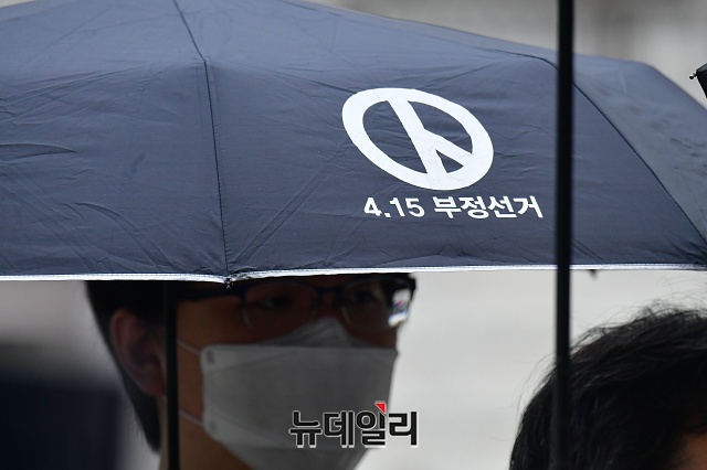 ▲ 26일 4.15 총선 의혹 규명 촉구를 위한 기자회견이 끝난 뒤 청와대를 향해 행진하던 한 시위 참석자가 '4.15 부정선거'라고 적힌 검정색 우산을 들고 있다.ⓒ권창회 기자
