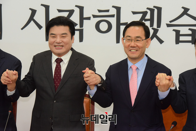 ▲ 주호영 미래통합당 원내대표와 원유철 미래한국당 대표가 28일 오전 국회에서 미래통합당-미래한국당 합당 선포식에서 참석자들과 함께 손을 맞잡고 있다.ⓒ이종현 기자