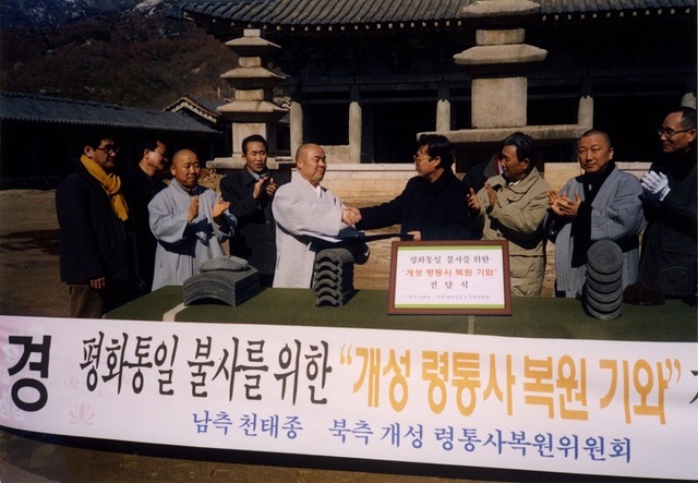 ▲ 대전 광수사 김무원 주지가 2003년 북한 개성에서 북한측 인사에게 영통사 복원에 필요한 기와를 전달하고 있다.ⓒ대전 광수사