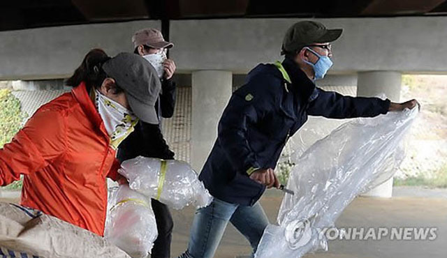 ▲ 2014년 10월 25일 경기도 파주시 임진강역 인근에서 마스크와 수건으로 얼굴을 가린 좌익성향 단체 회원들이 우파단체의 대북전단 풍선을 빼앗은 뒤 칼로 찢고 있다. ⓒ연합뉴스. 무단전재 및 재배포 금지