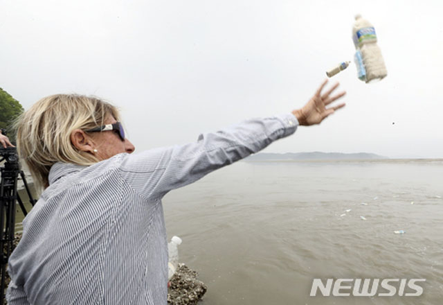 ▲ 2018년 5월 1일 임진강에서 쌀과 달러가 든 페트병을 던지는 국제인권단체 관계자. ⓒ뉴시스. 무단전재 및 재배포 금지.