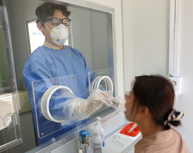 ▲ 선별진료부스는 검사대상자와 의료진을 투명한 벽으로 완벽하게 차단한 상태로 고정형 라텍스 장갑을 이용해 벽 너머 환자의 검체를 안전하고 간편하게 채취한다.ⓒ경주시