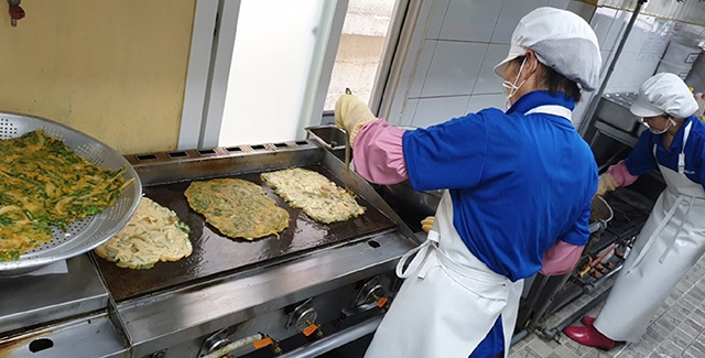 ▲ 실버복식품 직원들이 먹거리 안전을 위해 깨끗한 조리환경에서 위생 마스크, 앞치마, 장갑 등을 착용한 상태로 요리하고 있다.ⓒ포스코