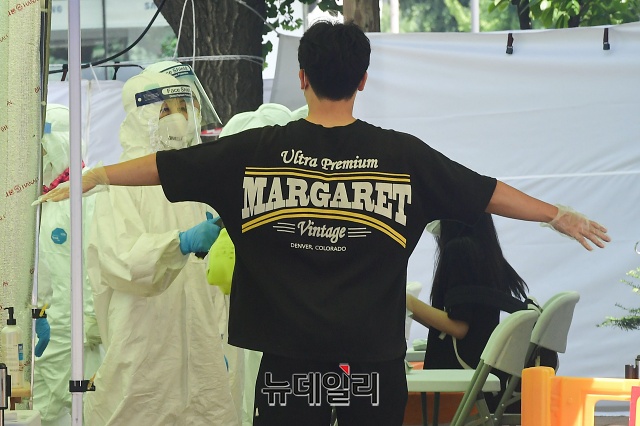 ▲ 16일 오후 서울 강서구 선별진료소를 찾은 한 시민이 검체 채취 전 소독을 하고 있다. ⓒ권창회 기자