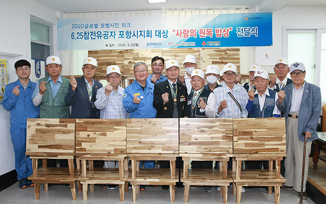 ▲ 포항제철소 임직원들이 22일 대한민국 6.25참전유공자회 포항시지회에서 참전용사들에게 원목밥상을 전달하며 기념사진을 찍고 있다.ⓒ포스코