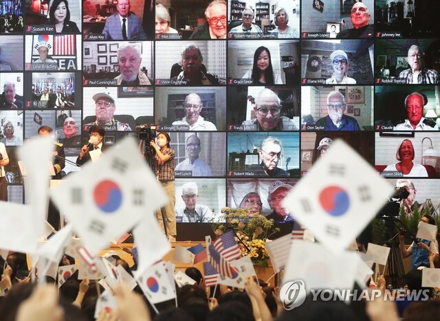 ▲ 지난 24일 오전 경기도 용인시 새에덴교회에서 열린 '제70주년 한국전쟁 참전용사 초청 온라인 보은행사'에서 참석자들이 미국, 캐나다, 필리핀, 태국 등에서 온라인으로 참석한 참전 용사들에게 각 나라 국기를 흔들며 인사하고 있다. ⓒ연합뉴스