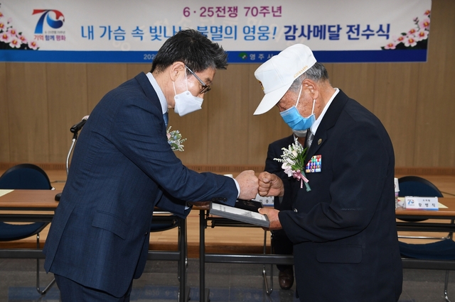 ▲ 장욱현 영주시장(왼쪽)이 25일 '내 가슴 속 빛나는 불멸의 영웅! 감사메달(은화形)'을 전수하고 있다.ⓒ영주시