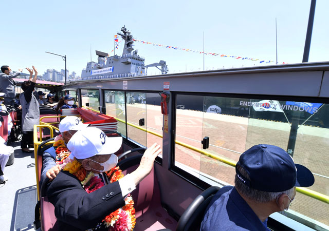▲ 26일 오전 대한해협해전 참전용사들과 유가족들이 부산작전기지에 정박 중인 독도함 장병들의 환영을 받고 있다. 이날 부산작전기지에 정박 중이 함정들은 만함식으로 함정 전체에 깃발을 내걸고 마스트에는 'REMEMBER' 기류를 게양했다. ⓒ해군 제공.
