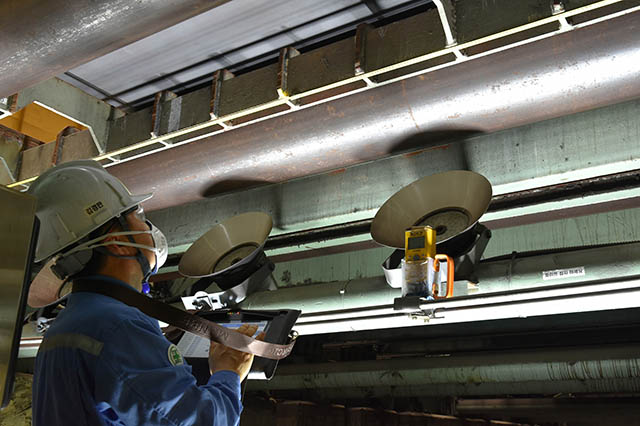 ▲ 포항제철소 후판부 직원이 제품 표면에 생긴 흠집 간의 거리를 테블릿 기기에 입력해 변형이 생긴 날판이송설비 부품을 찾아내고 있다.ⓒ포스코