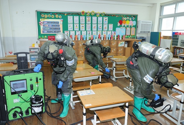 ▲ 국군화생방사령부 소속 장병들이 코로나19 확진자가 발생한 대전 천동초등학교에서 지난 3일 교실에서 정밀제독작업을 하고 있다.ⓒ대전시