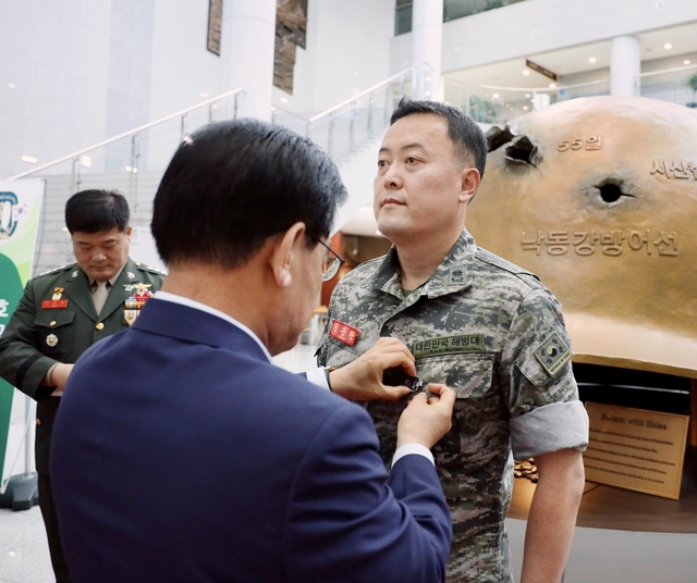 ▲ 백선기 칠곡군수가 연평도 포격에 참전한 권준환 예비역 해병 소령에게 호국영웅 배지를 달아주고 있다.ⓒ예천군