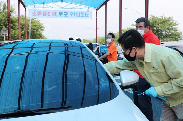 ▲ 양승조 충남도지사가 지난 4일 대천해수욕장 입구에서 승용차 탑승객을 대상으로 코로나19 예방을 위해 발열체크를 하고 있다.ⓒ충남도