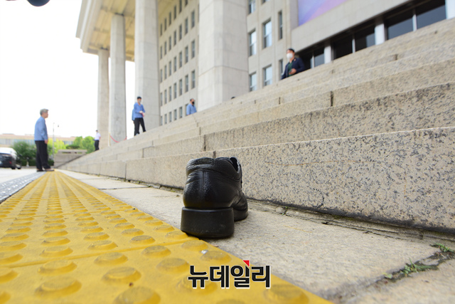 ▲ 16일 오후 3시19분경 서울 영등포구 국회 본회의장에서 21대 국회 개원 연설을 마치고 나온 문재인 대통령을 향해 날아온 검은 구두. ⓒ이종현 기자