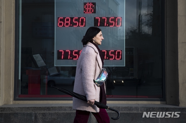 ▲ [모스크바=AP/뉴시스] 지난 3월 러시아 모스크바에서  한 여성이 미 달러화와 유로화의 러시아 루블 간 환율이 표시된 환전소 전광판 앞을 지나가고 있다.ⓒ뉴시스