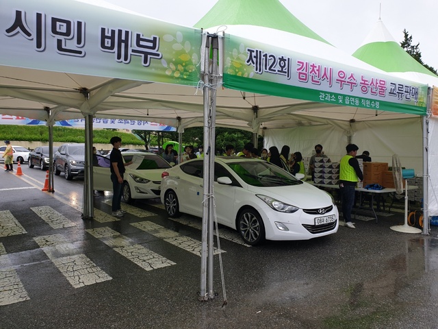 ▲ 김천시(시장 김충섭)는 지난 23일 자매도시인 군산시를 방문해 농특산물 직거래행사를 진행했다. 사진은 사전예약 주문건을 드라이브 스루 방식으로 진행하는 장면.ⓒ김천시