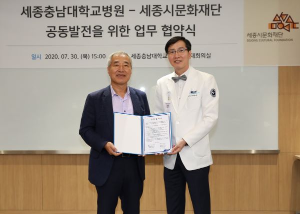 ▲ 세종충남대병원 나용길 원장(사진 오른쪽)과 세종시문화재단 김종률 대표이사가 협약서에 서명한 뒤 기념촬영을 하고 있다.ⓒ세종충남대병원