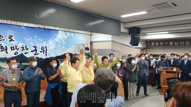 ▲ 김영만 군수와 이철우 도지사, 권영진 대구시장이 30일 저녁 군위군청 3층 대회의실에서 조건부 유치신청을 발표하고 손을 들어 보이고 있다.ⓒ뉴데일리