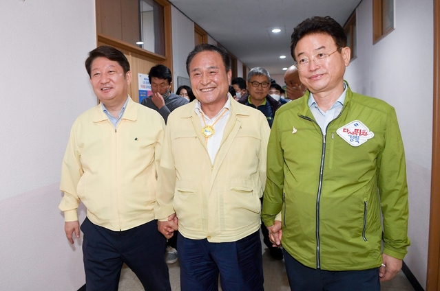 ▲ 이철우 지사(오른쪽)가 30일 저녁 합의문 발표를 위해 군위군청에서 권영진 시장(왼쪽)과 김영만 군위군수(중간)과 손을 잡고 행사장에 들어서고 있다.ⓒ경북도