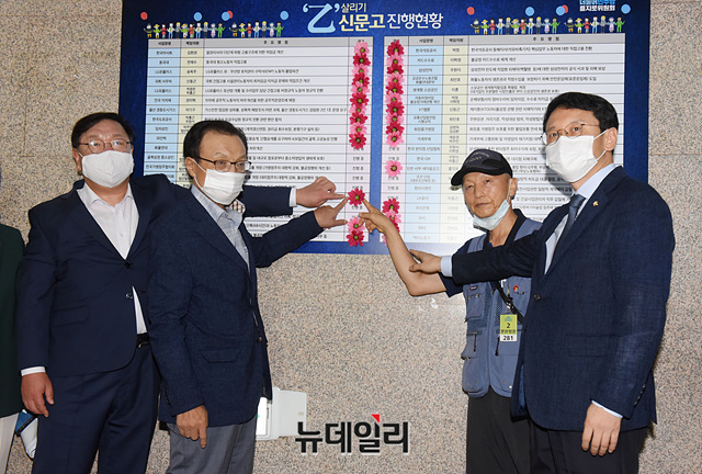 ▲ 이해찬 더불어민주당 대표, 김태년 원내대표, 천준호 의원이 5일 오전 국회에서 열린 을지로의원회 상생 꽃 달기 행사에서 아파트경비노동자들과 함께 상생 꽃을 달고 기념촬영을 하고 있다. ⓒ박성원 기자