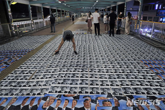 ▲ 지난해 10월 1일 홍콩 레넌벽 주변 바닥에 시진핑 중국 공산당 총서기 사진으로 도배를 하는 민주파 시위자. ⓒ뉴시스 AP. 무단전재 및 재배포 금지.