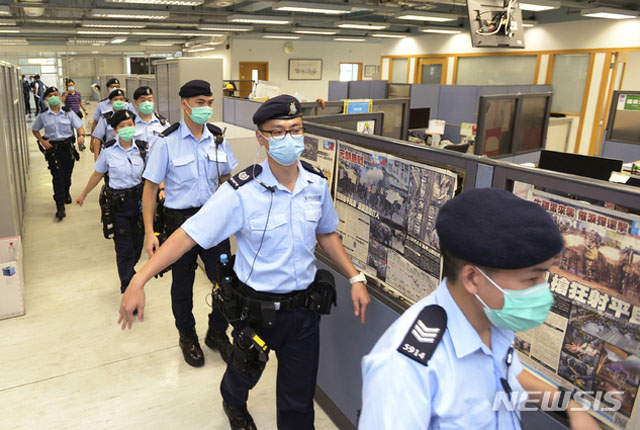 ▲ 다른 언론들에게 취재를 허락한 뒤 빈과일보 편집국을 압수수색하러 들어가는 홍콩 안보처 경찰들. ⓒ뉴시스 AP. 무단전재 및 재배포 금지.