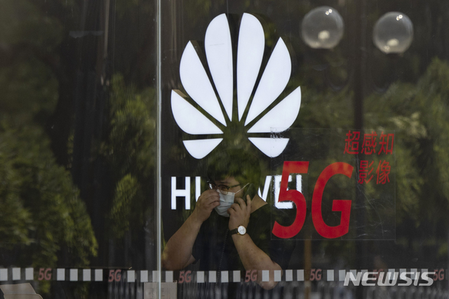 ▲ [베이징=AP/뉴시스] 중국 베이징의 한 화웨이 매장에서 마스크를 착용한 직원이 통화를 하는 모습.ⓒ뉴시스