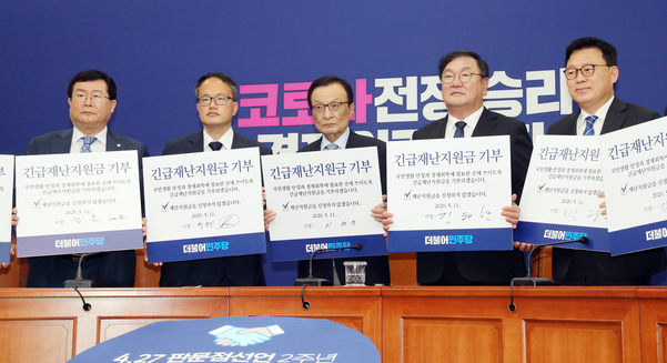 ▲ 더불어민주당 이해찬 대표와 김태년 원내대표 등 의원들이 5월 11일 오전 서울 여의도 국회에서 열린 최고위원회의에서 긴급재난지원금 기부 서약서를 들어 보이고 있다. ⓒ연합뉴스