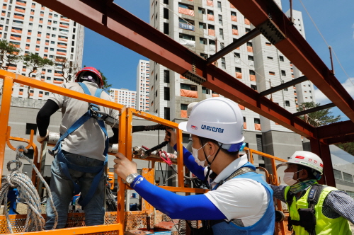 ▲ e편한세상 금정산 현장에서 대림산업 안전관리자와 협력사 직원들이 안전벨트를 비롯한 보호구 착용을 점검하고 있다. ⓒ 대림산업
