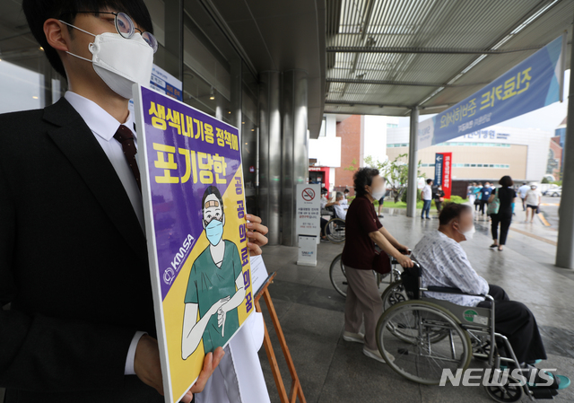 ▲ 정부가 추진하는 의과대학 정원 증원 정책 등에 반대하는 의료계가 집단행동에 돌입, 종합병원 수련 전공의부터 순차 휴진에 들어간 21일 서울 종로구 연건동 서울대학교병원에서 의대 본과 3학년생이 1인시위를 하고 있다. ⓒ뉴시스