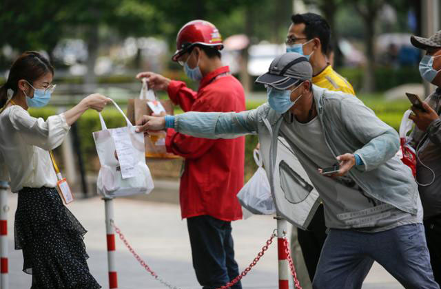 ▲ 경계선 너머로 주문받은 음식을 주고 받는 베이징 시민들. 중국 당국은 