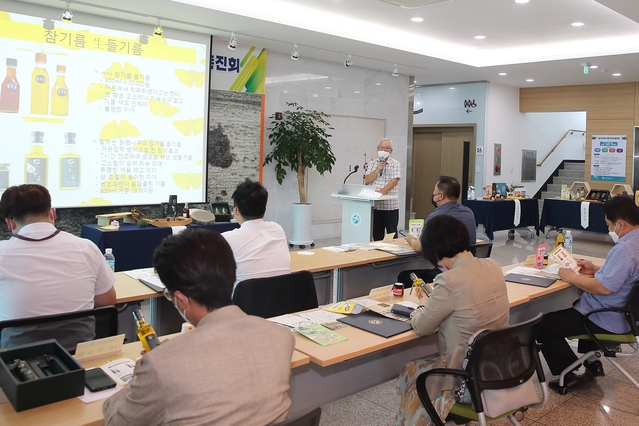 ▲ 각산마을협동조합 장세완 이사장이 참기름과 생들기름을 바이어에게 설명하고 있다.ⓒ칠곡군농업기술센터