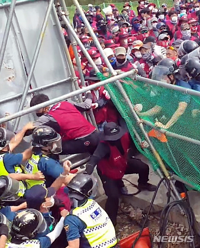 ▲ 8일 전북 군산 비응도동의 건설 현장 앞에서 부당노동행위를 중단을 요구하는 플랜트건설노조 조합원 등의 집회에 경찰 병력이 투입돼 대치하고 있다. ⓒ뉴시스